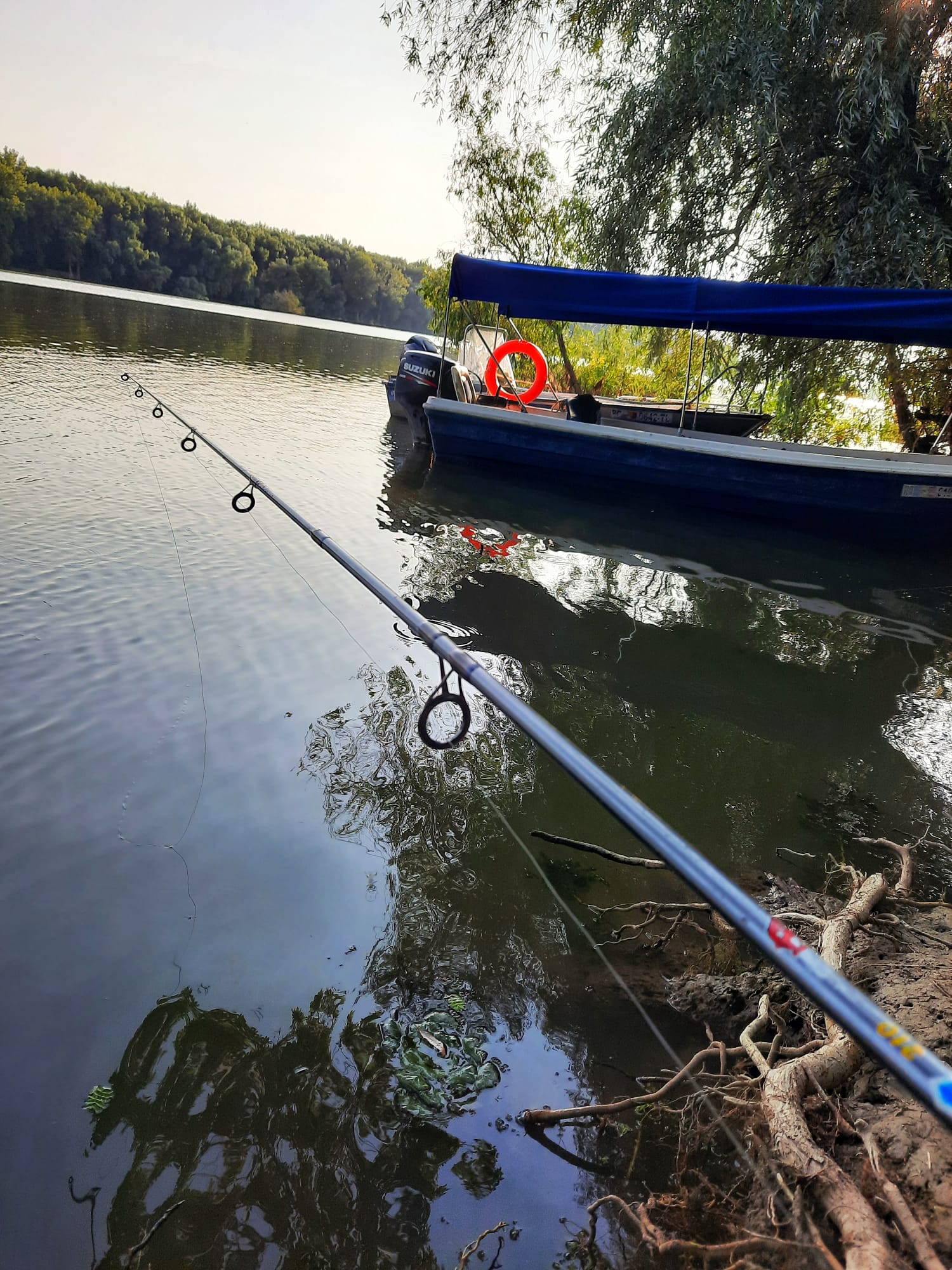A quiet moment fishing beside a moored boat at golden hour